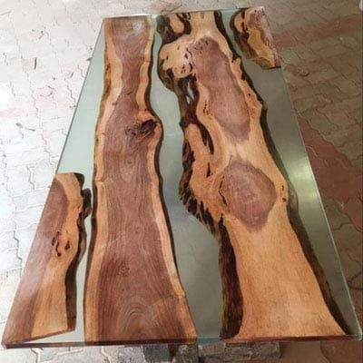 Der Tisch besteht aus Holz und Glas und sieht aus wie ein Fluss.
