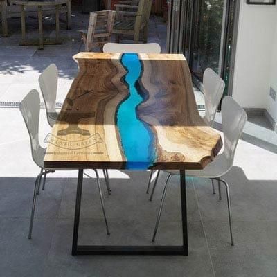 Ein Holztisch mit einem Fluss in der Mitte und Stühlen.
