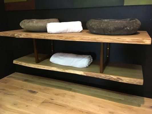 Ein Holzregal mit zwei Handtüchern und zwei Waschbecken darauf