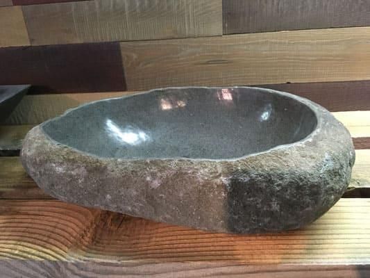 Auf einem Holztisch steht eine Steinschale.