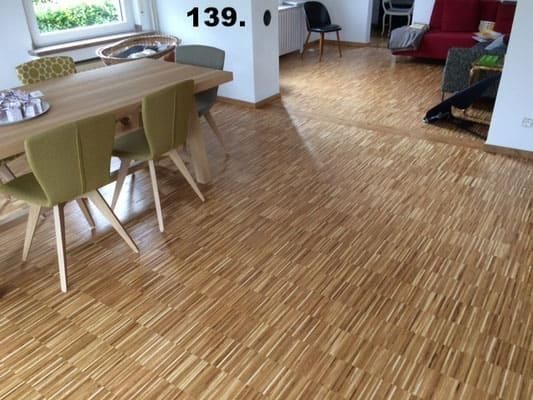 Ein Wohnzimmer mit Holzboden und einem Tisch und Stühlen