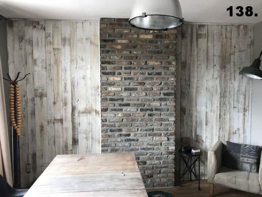 Ein Wohnzimmer mit einer Ziegelwand und einem Holztisch