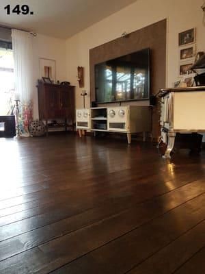 Ein Wohnzimmer mit Holzboden und einem Flachbildfernseher.