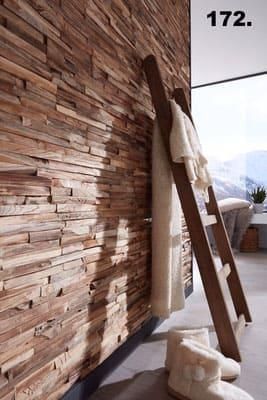 An einer Holzwand hängt eine Holzleiter.