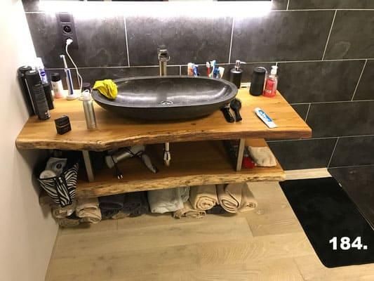 Ein Badezimmer mit einem Waschbecken auf einem Holzregal.