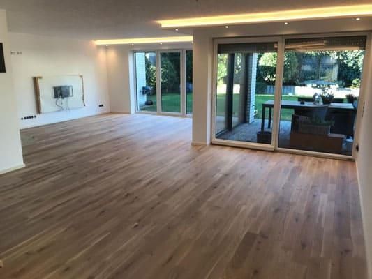 Ein leeres Wohnzimmer mit Hartholzböden und Glasschiebetüren