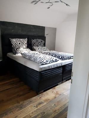 Ein Schlafzimmer mit einem Bett und einem Holzboden.