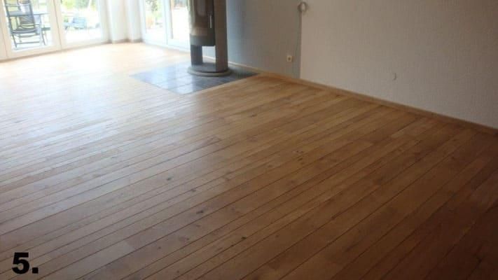 Ein leerer Raum mit Holzboden und Kamin.