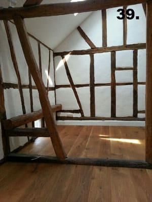 Ein Raum mit einer Holztreppe und einer Holzbank.