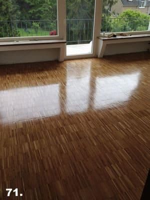 Ein Wohnzimmer mit Holzboden und großem Fenster.