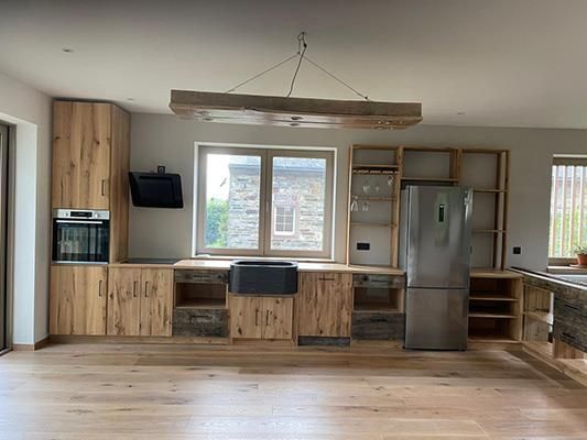 Eine Küche mit Holzschränken und einem Edelstahlkühlschrank.