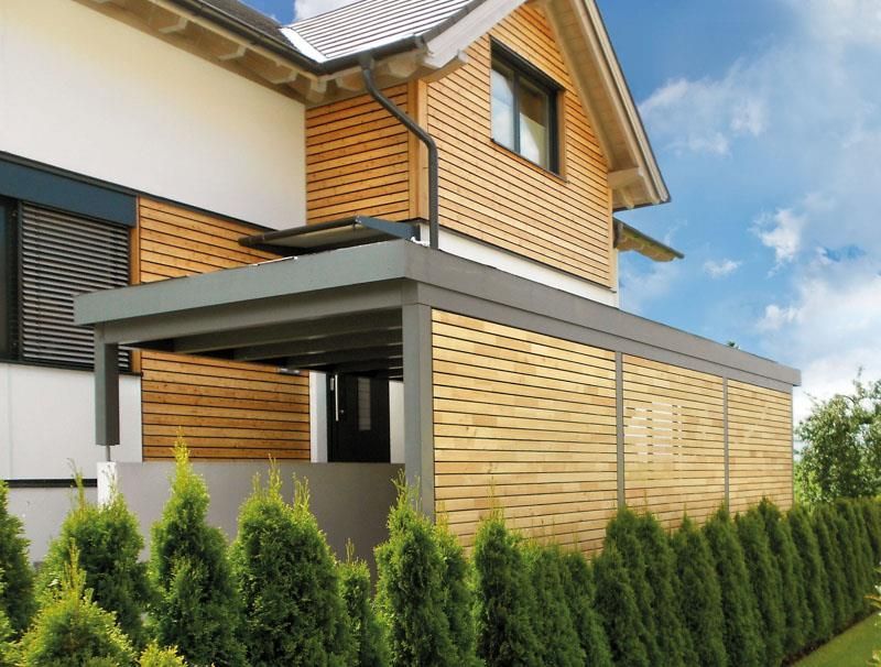 Ein Haus mit einer hölzernen Pergola an der Seite
