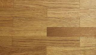 Eine Nahaufnahme eines Holzbodens mit einem diagonalen Muster.