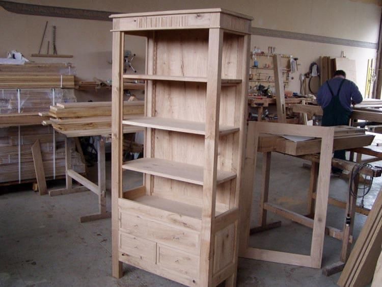 Ein Mann arbeitet in einer Werkstatt an einem Holzregal