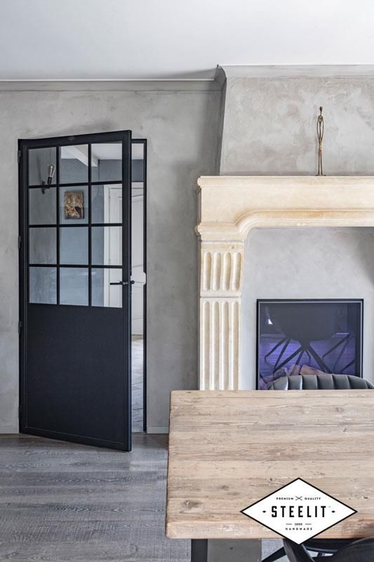 Ein Wohnzimmer mit Kamin und schwarzer Tür