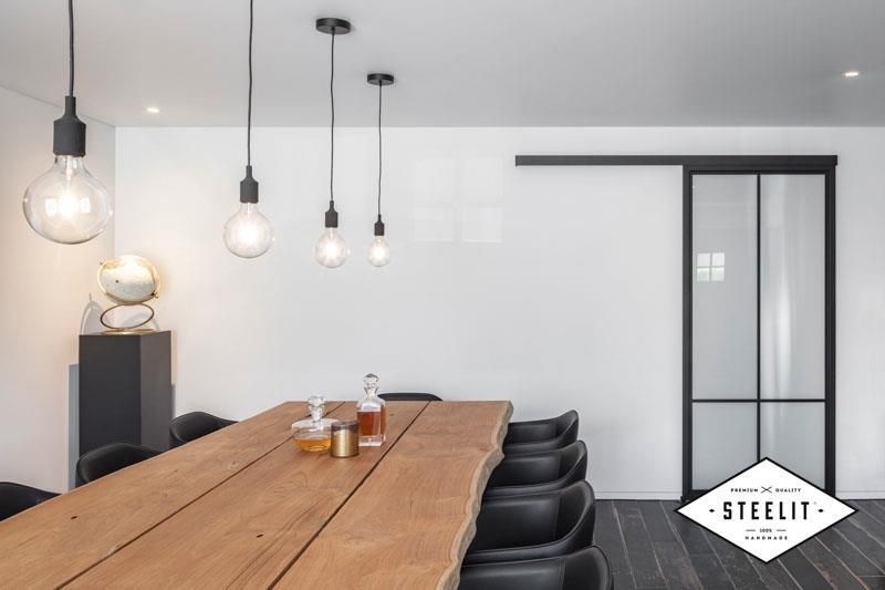 Ein Esszimmer mit einem Holztisch und Stühlen und einer Glasschiebetür.