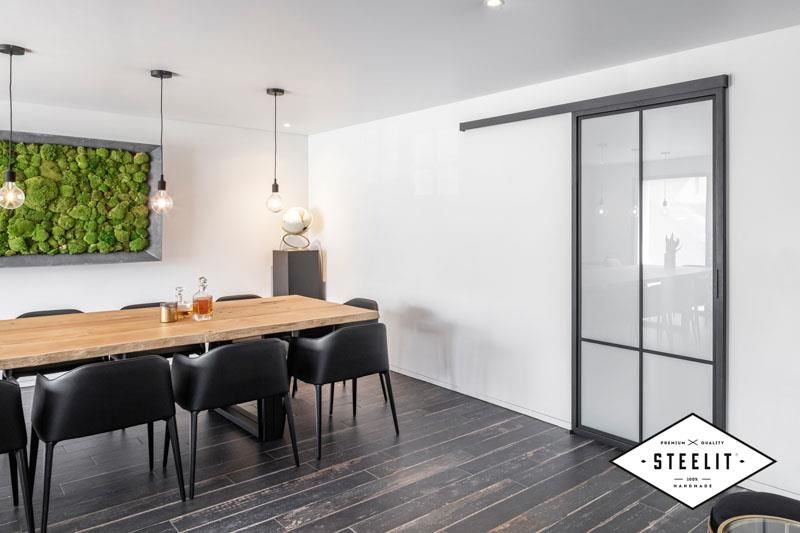 Ein Esszimmer mit Tisch und Stühlen und einer Glasschiebetür.