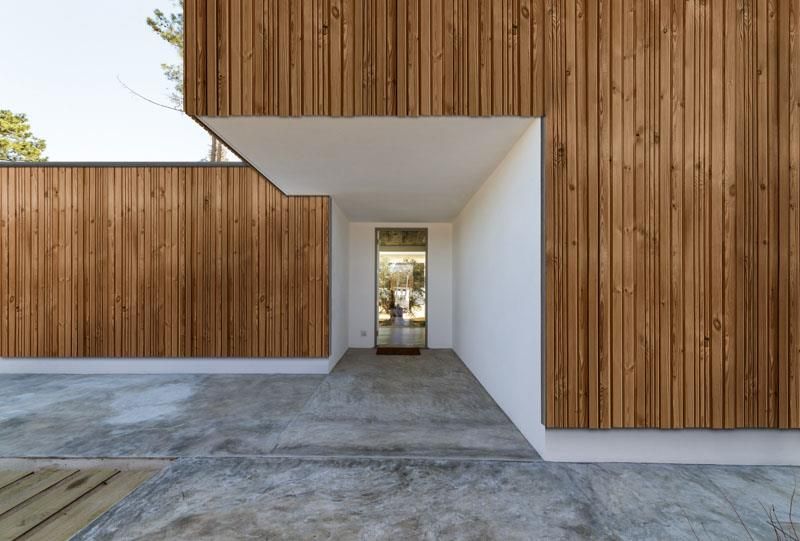 Ein Haus mit einer Holzfassade und einem Betonweg