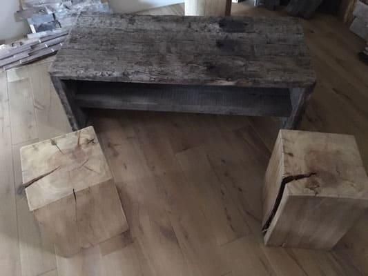 Ein Couchtisch und zwei Holzhocker stehen auf einem Holzboden.