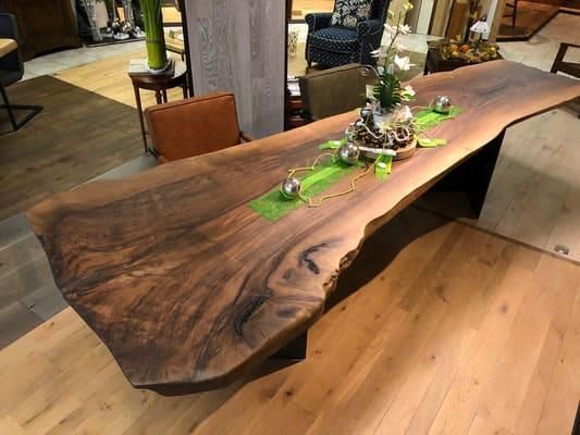 Ein Holztisch mit einer Vase mit Blumen darauf.