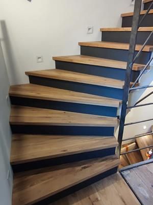 Eine Wendeltreppe mit Holzstufen und Metallgeländer.