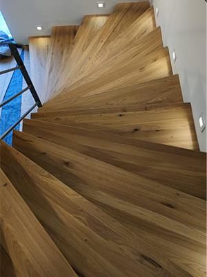 Eine hölzerne Wendeltreppe mit einem Metallgeländer in einem Haus.
