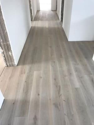 Ein Flur mit Holzboden und weißen Wänden.