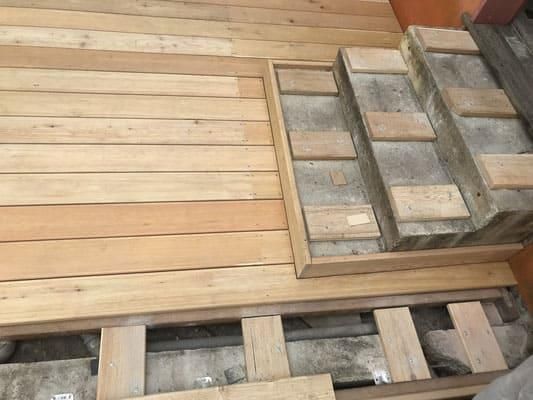 Ein Holzdeck mit eingebauter Treppe.
