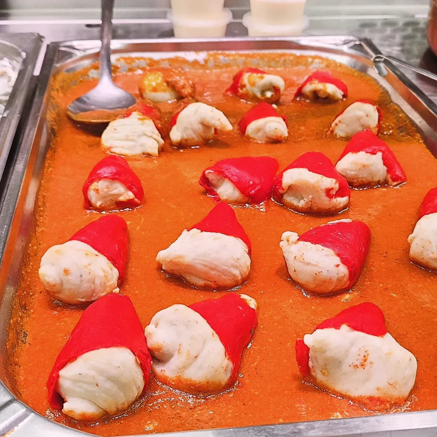 Bandeja de postres de pastel de fresa con forma de gorro de Papá Noel sobre una superficie de color naranja brillante.