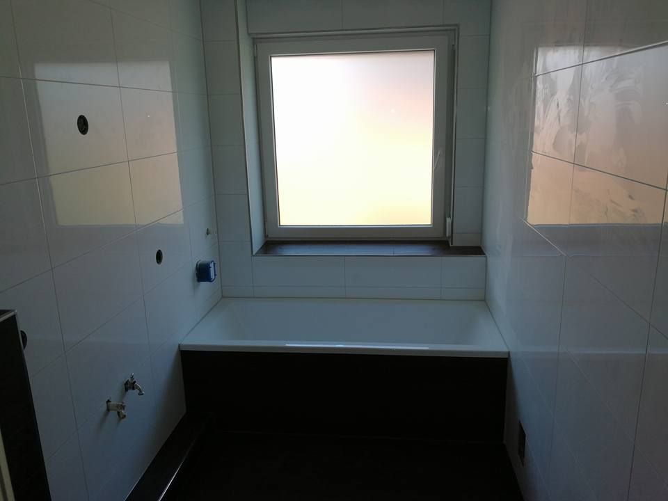 Ein Badezimmer mit Badewanne und Fenster