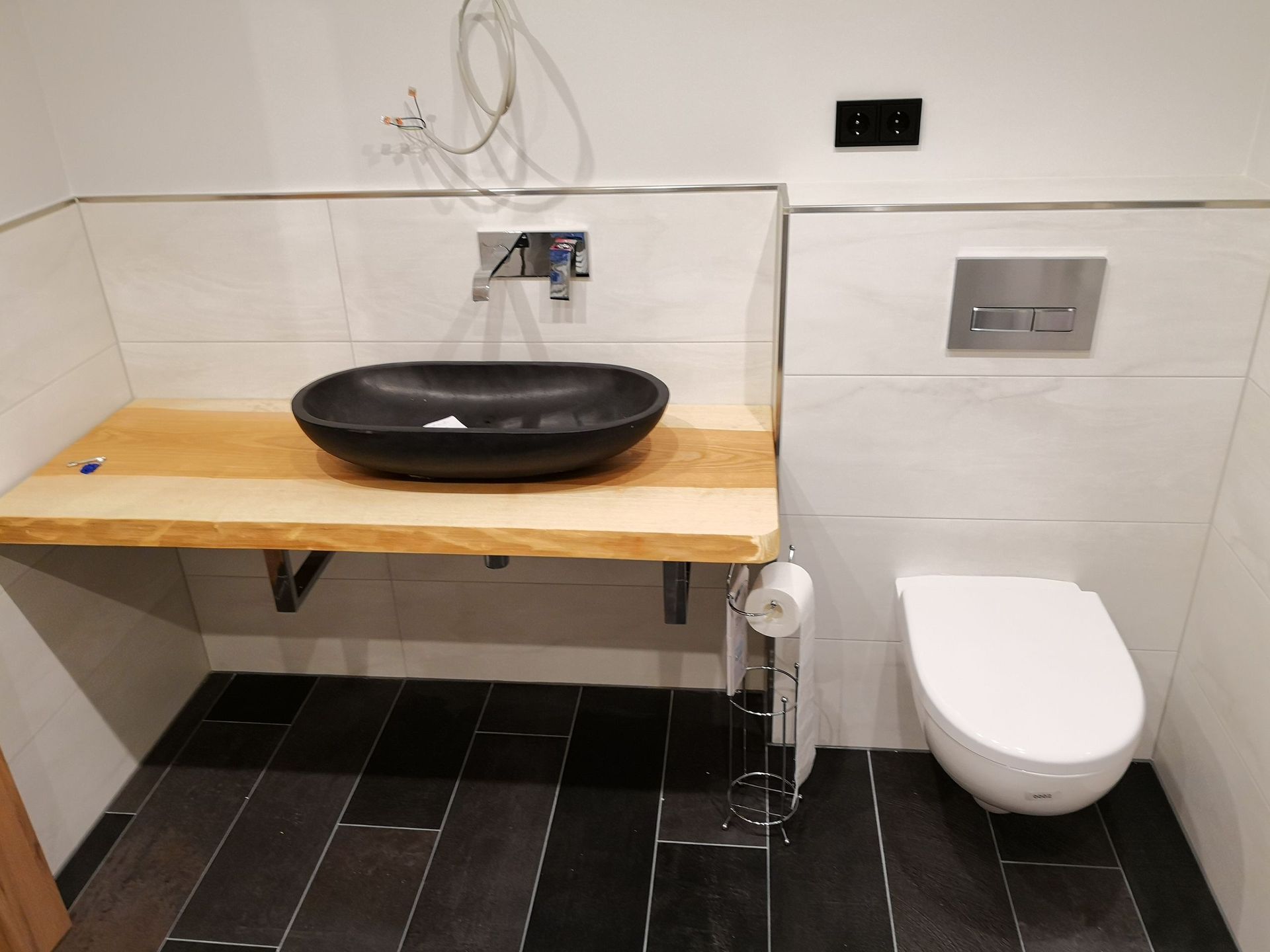 Ein Badezimmer mit einem schwarzen Waschbecken und einer weißen Toilette