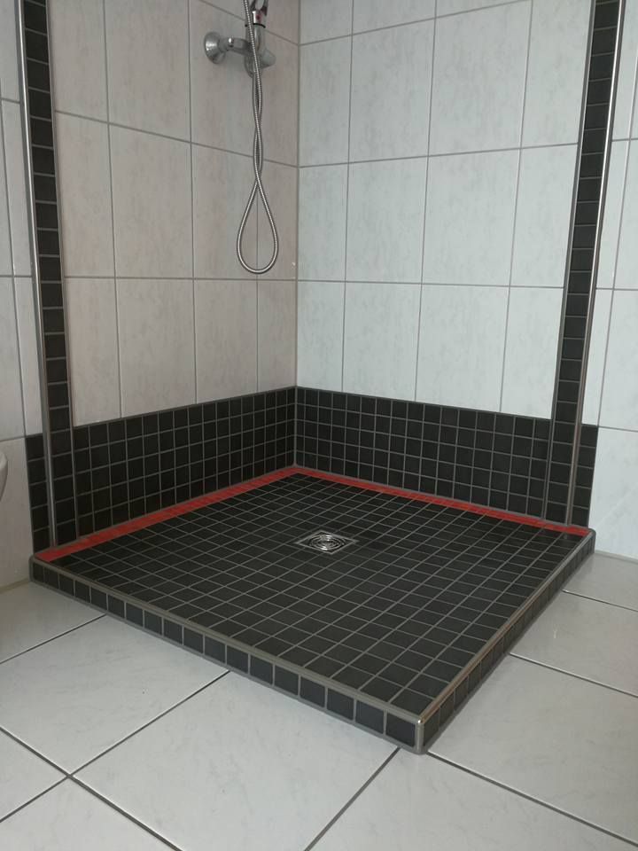 Eine Duschkabine mit schwarzen und weißen Fliesen