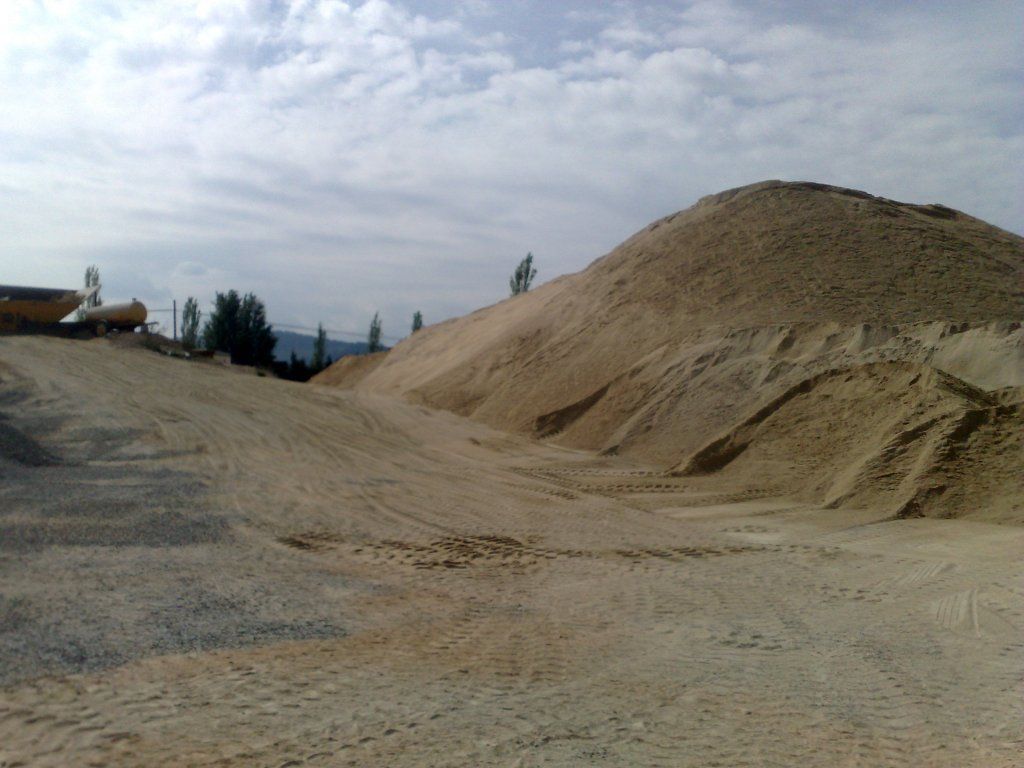 Un gran montón de tierra se encuentra en medio de un camino de tierra.
