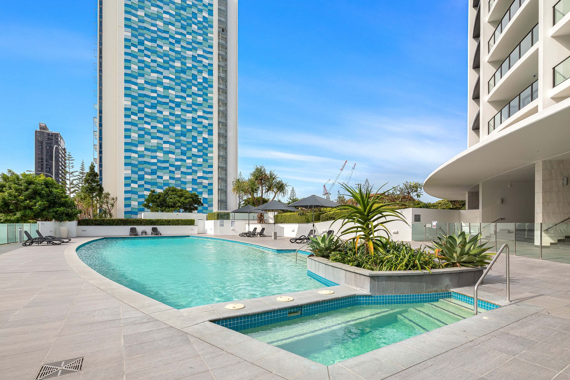 There is a large swimming pool in front of the Sierra Grand Resort building Surfers Paradise
