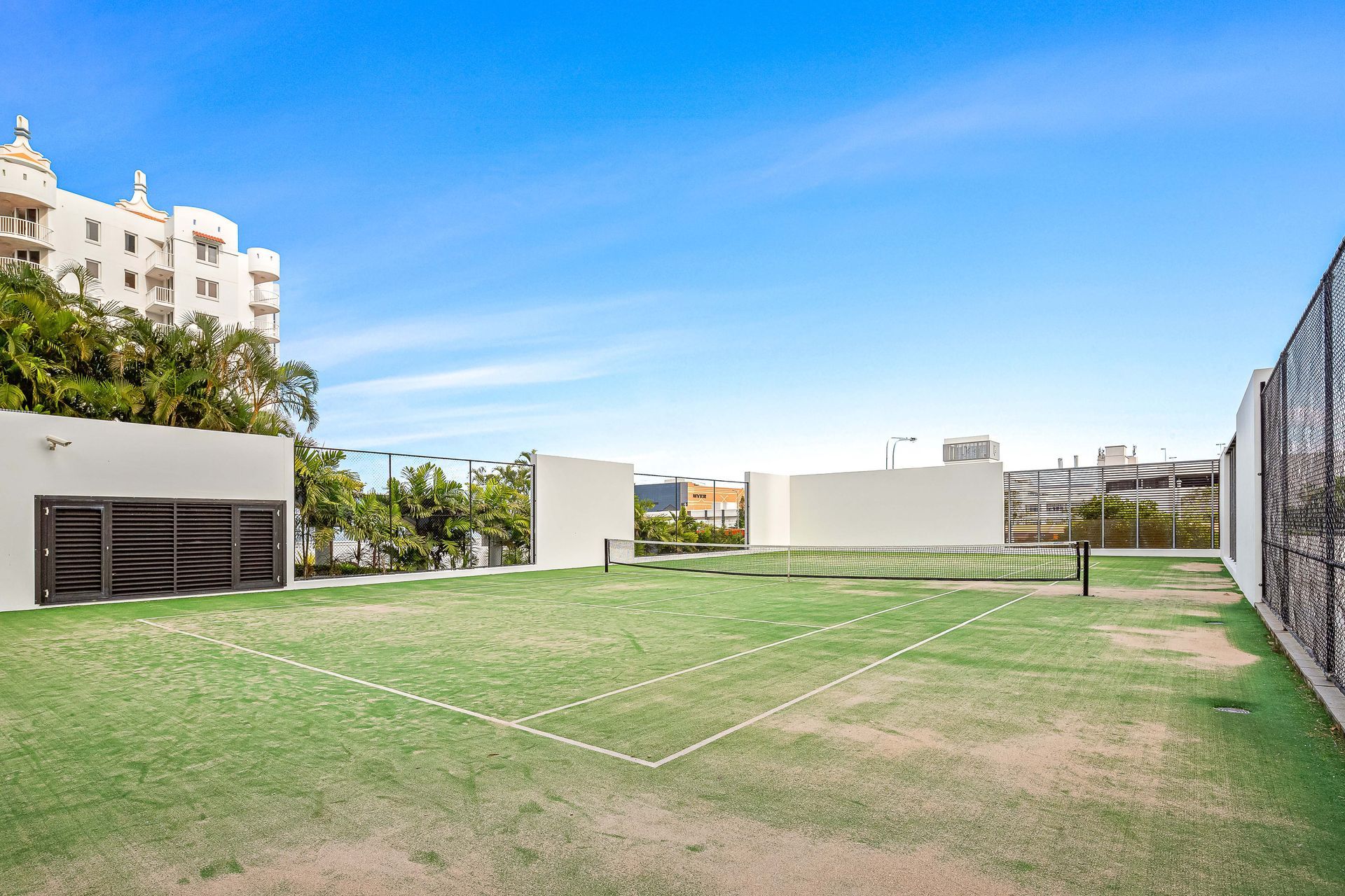 A tennis court with a fence. IN the Sierra Grand Resort Surfers Paradise