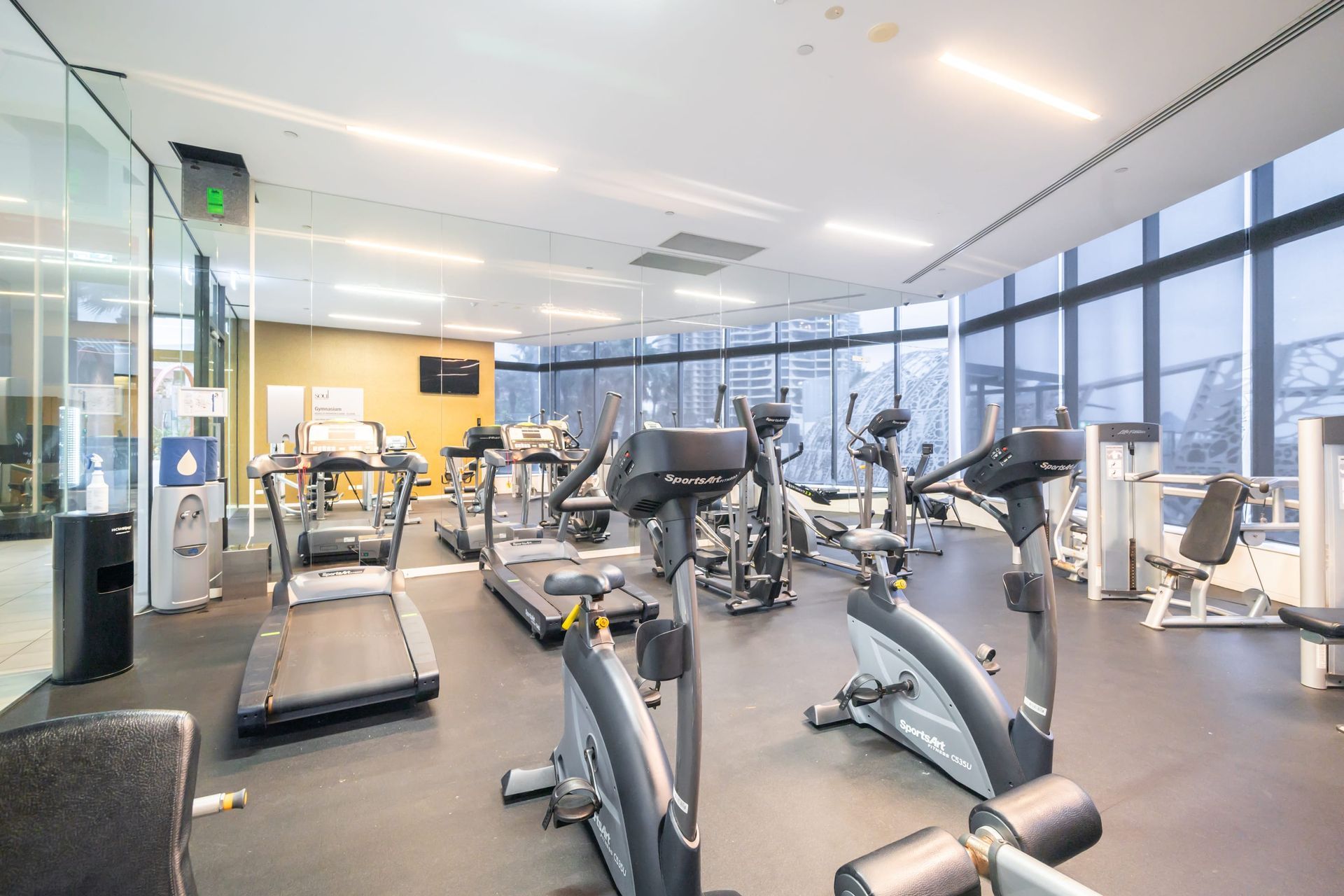 A large gym with a lot of equipment and big windows in the Soul facility