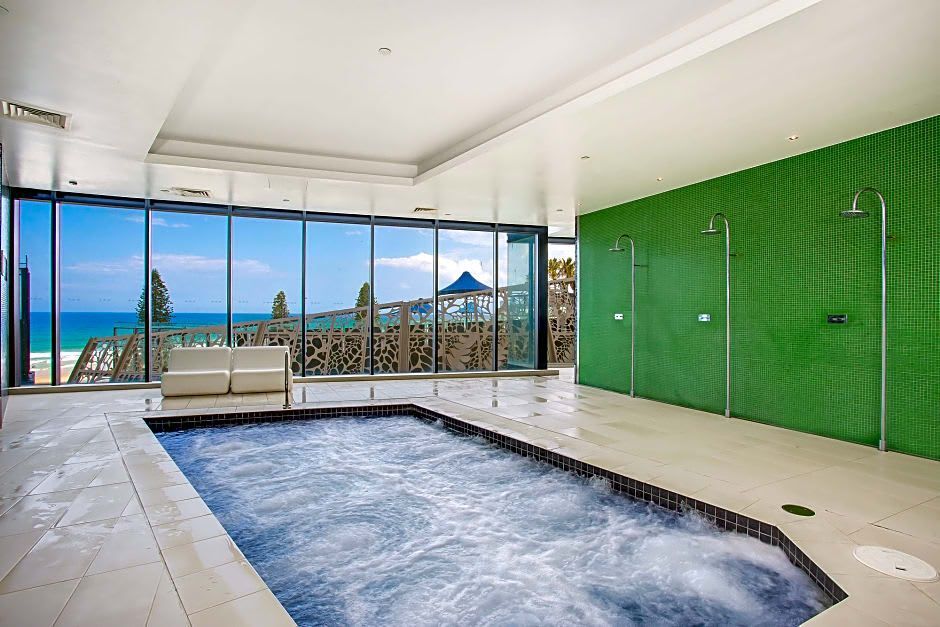 A large indoor swimming pool with a view of the ocean. In the Soul Resort Surfers Paradise