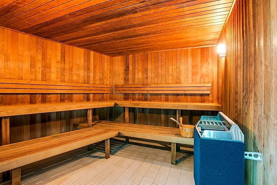 A wooden sauna with benches and a heater. In the Soul resort