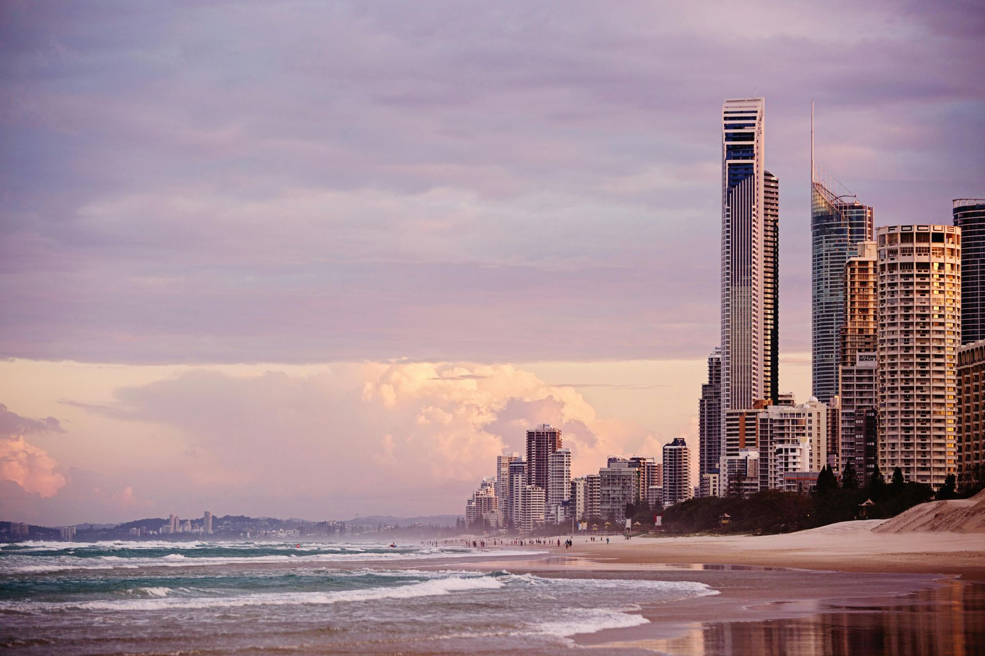 A beach with a city skyline in the background at sunset. Gold cOats, Surfers Paradise
