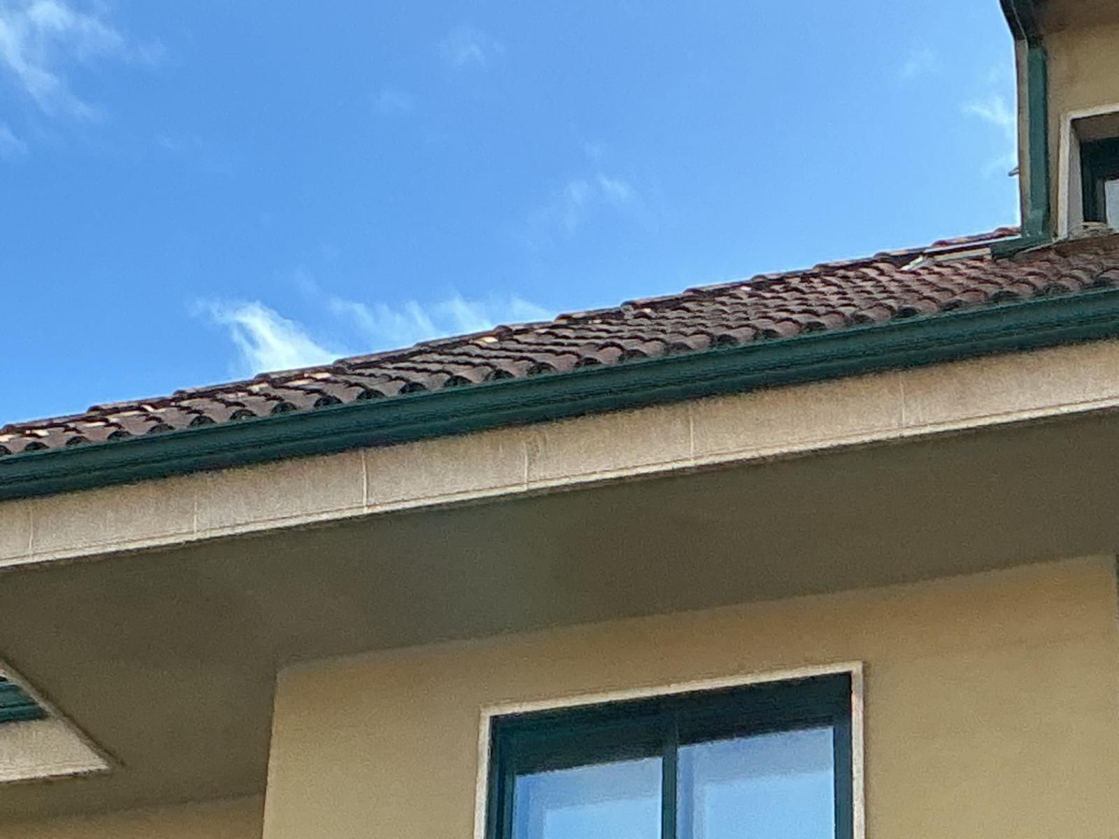 Techo y ventana de la casa contra un cielo azul