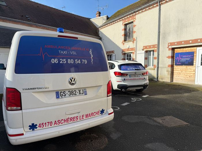Arrière d'une ambulance et d'un taxi VSL dans une cour fermée