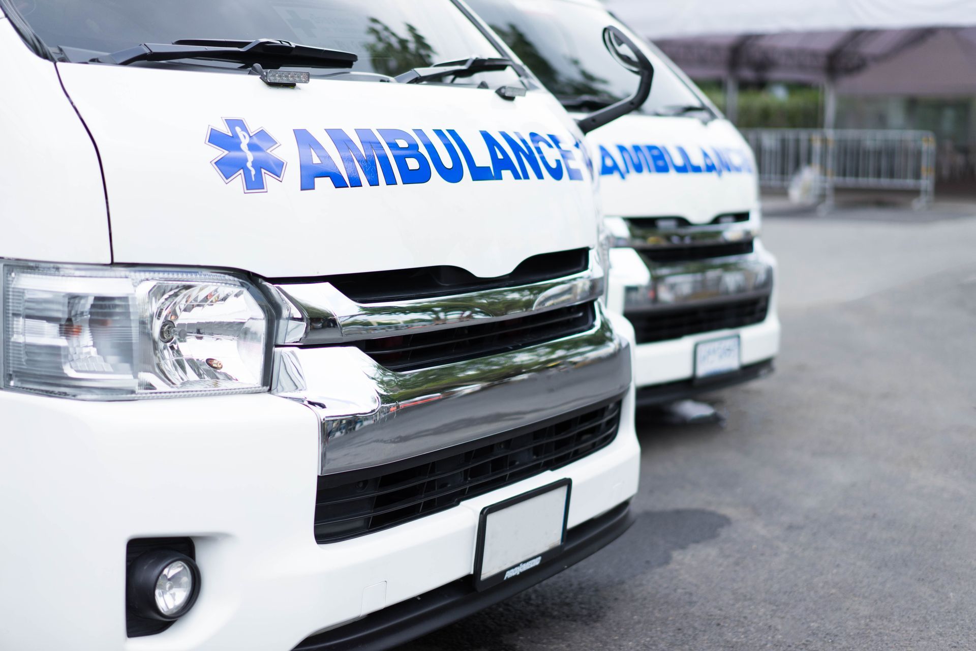 Deux ambulances blanches avec l'emblème de l'étoile de vie sur un parking en extérieur.