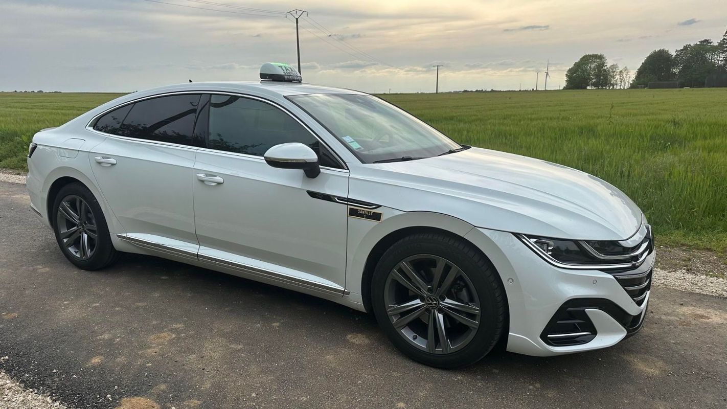 Berline sur une route en bordure de champ avec pelouse