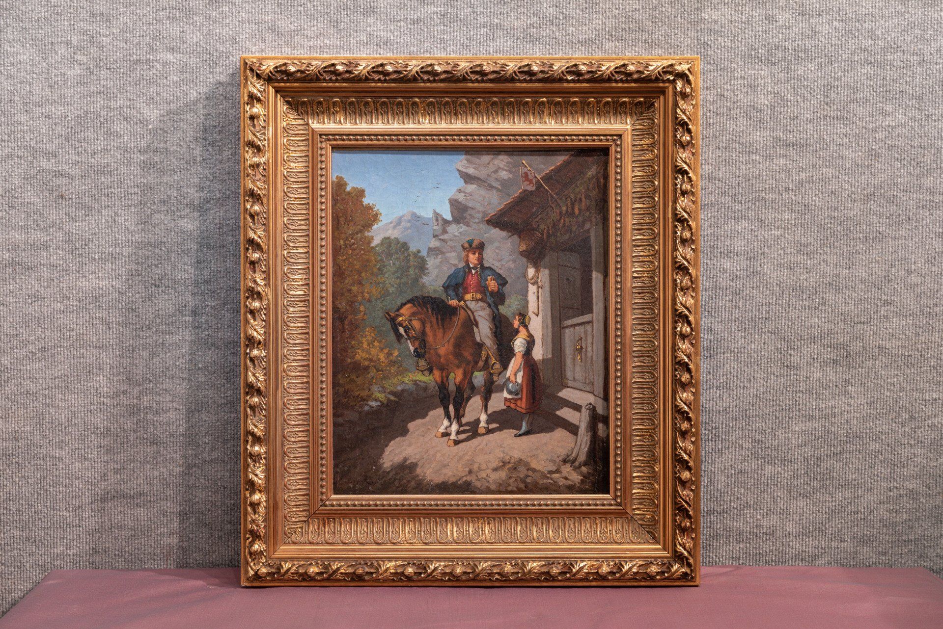 Un tableau encadré représentant un cavalier sur un cheval brun