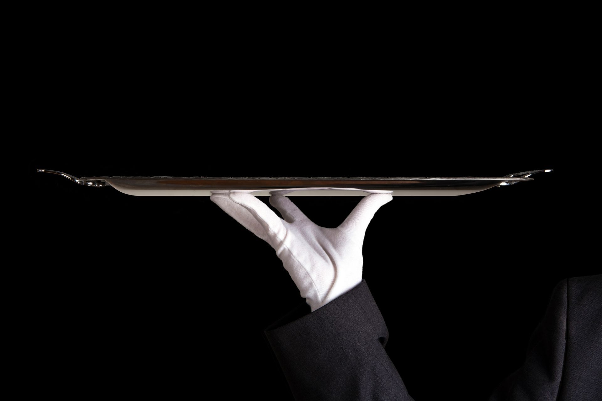 Un serveur portant des gants blancs tient un plateau en argent.