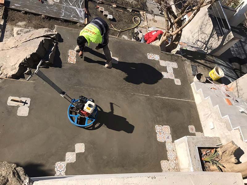 Obreros vertiendo hormigón fresco en una obra en construcción en la azotea.