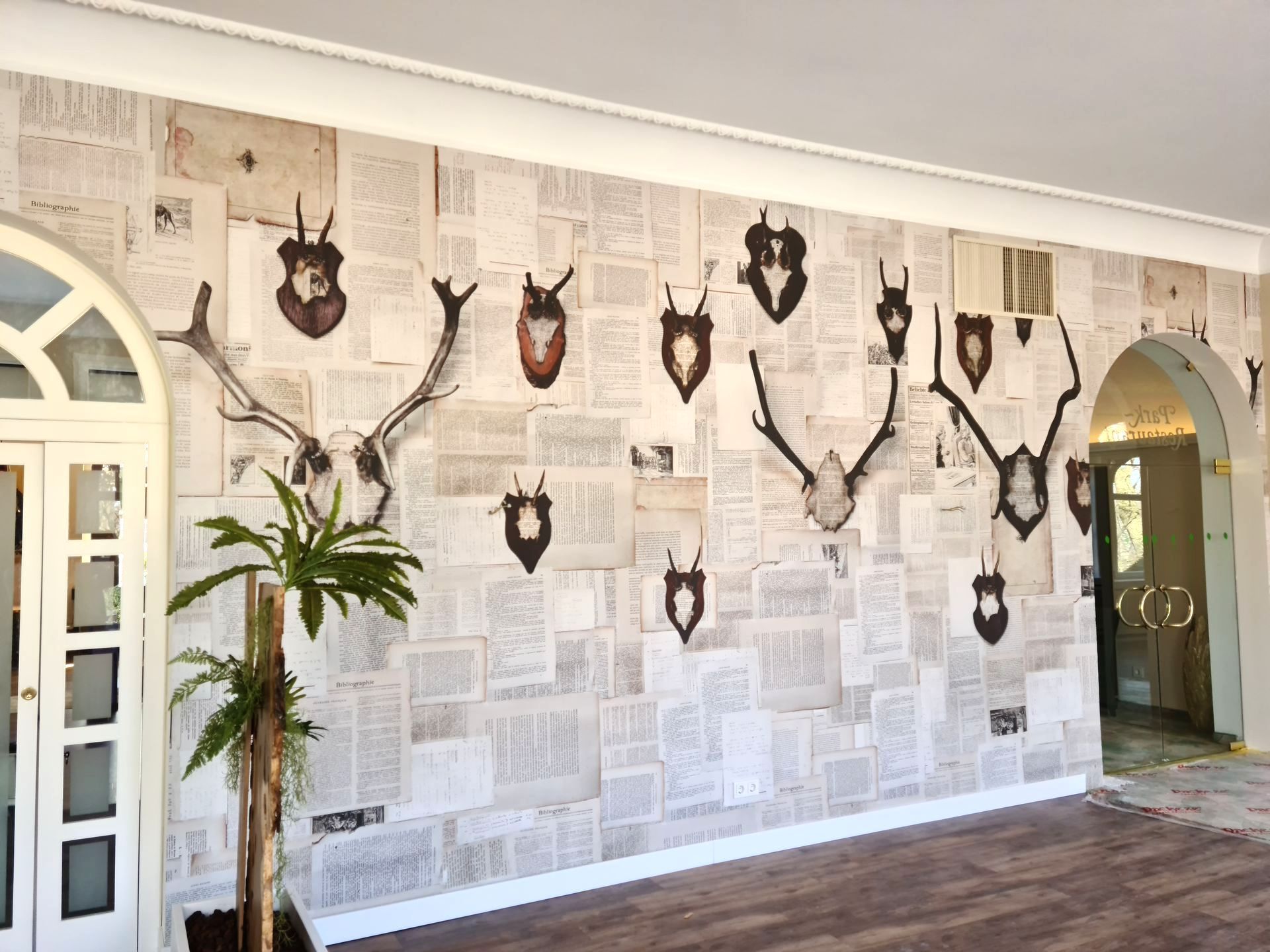 Eine große Wand mit gemusterter Tapete im Zeitungsdesign