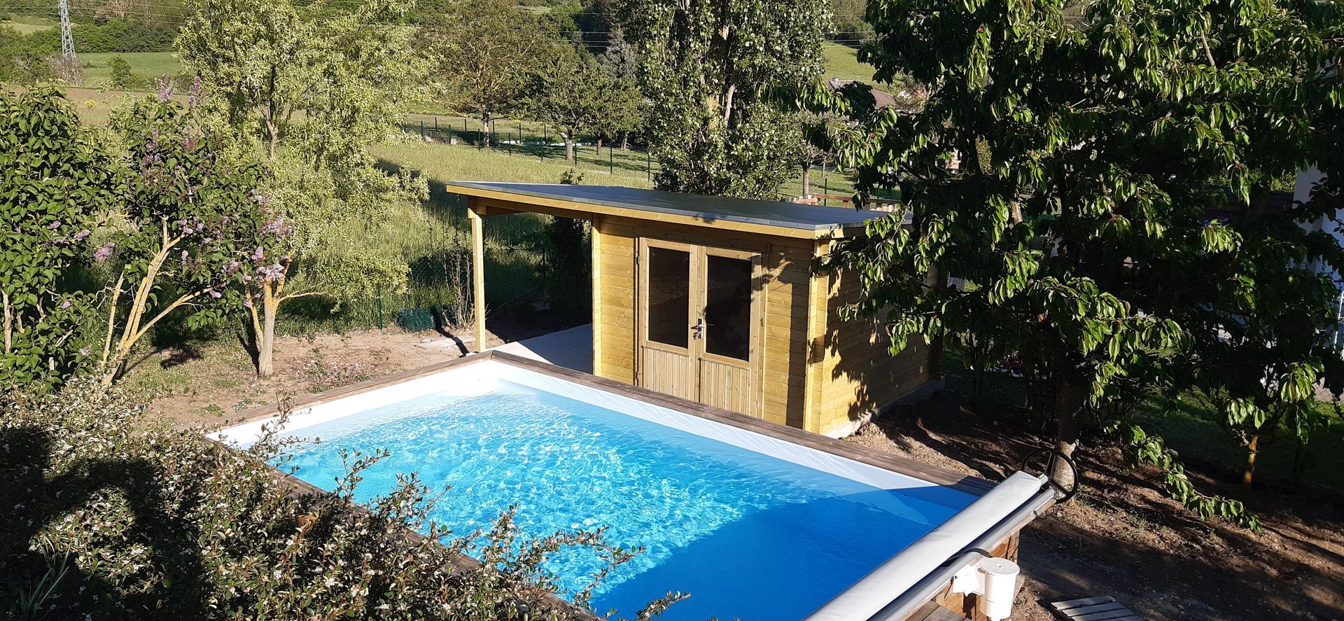 Chalet collé à la piscine avec préau