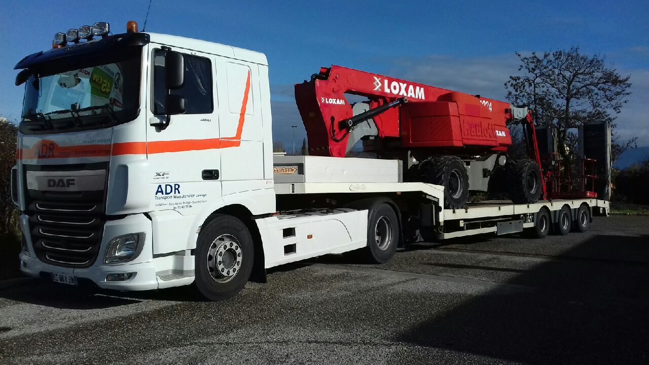 Camion semi-plateau avec engin dessus