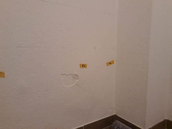 Eine Zimmerecke mit einer weißen Wand und gelben Aufklebern darauf.